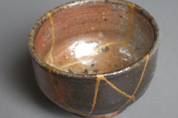 Image by Haragayato, used under a CC 4.0 license. Kintsugi bowl with cracks filled in with gold.