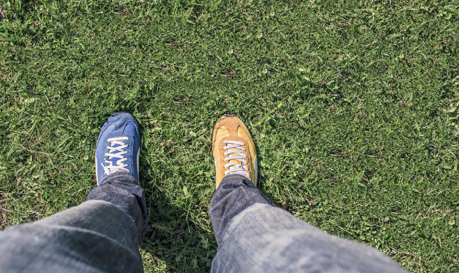 Don't let inequality sabotage your success - Person wearing two different shoes, one blue, one yellow.